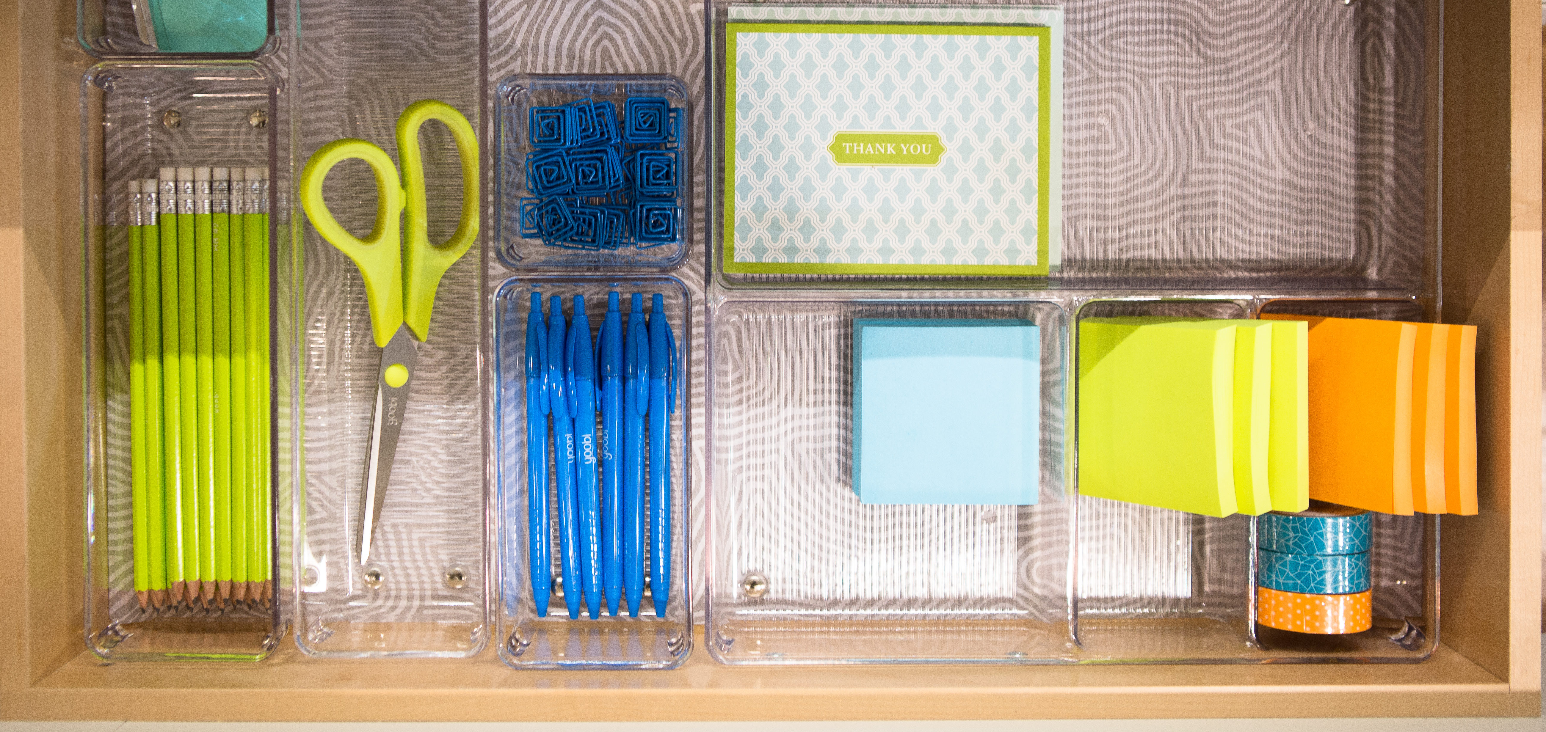 organized office drawer with sticky notes and scissors